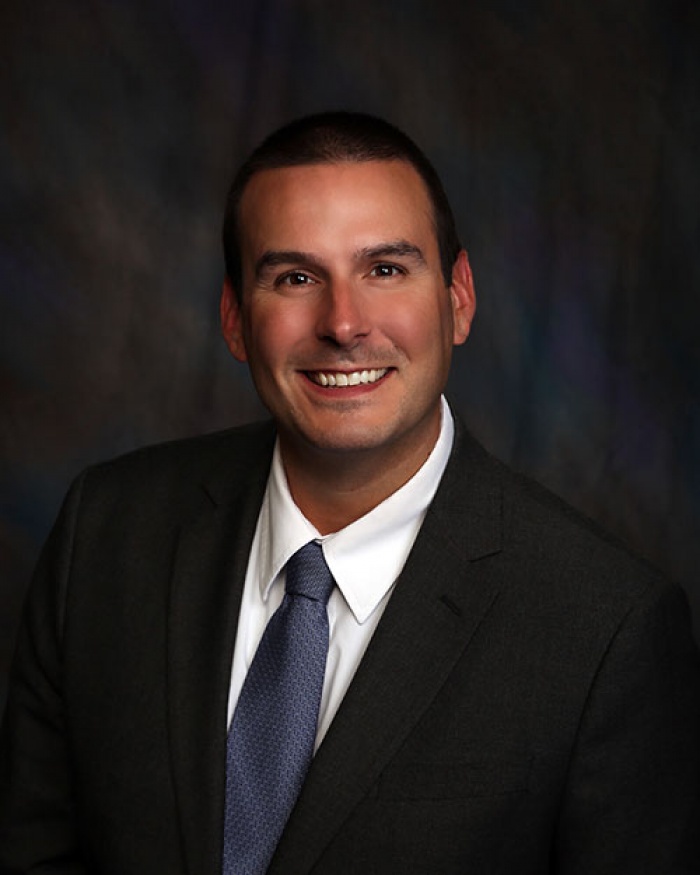 A smiling man in a suit and tie