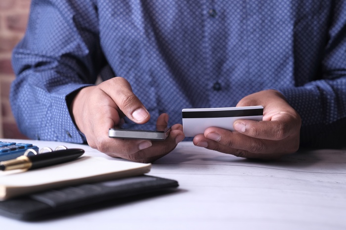 A business man makes an online purchase with his credit card.