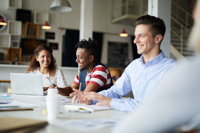 A happy business team has a meeting around a conference table