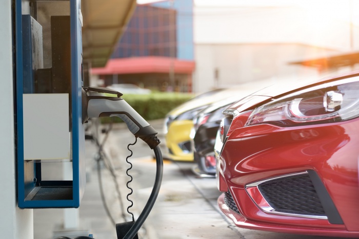 An electric car sits parked and charging