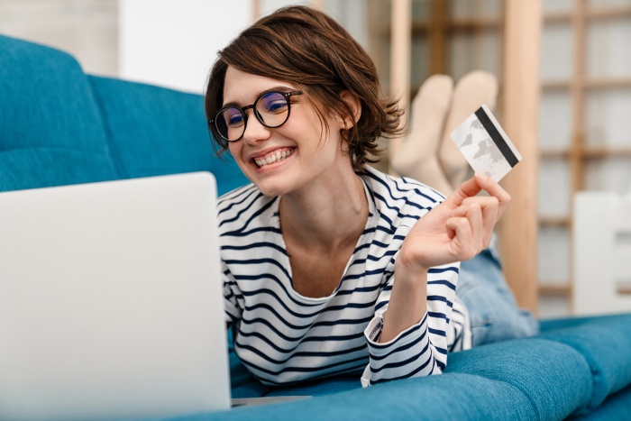 A woman shops online using her Emerald Visa® card.