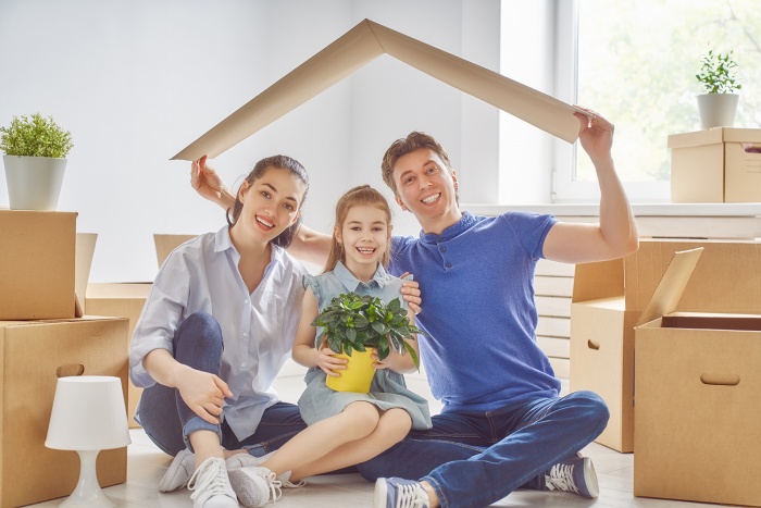 A family plays with boxes in their new home