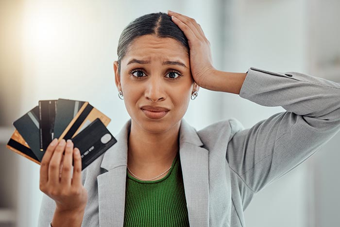 Financially stressed woman holding many credit cards