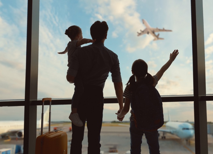 Happy family at the airport waving at airplane