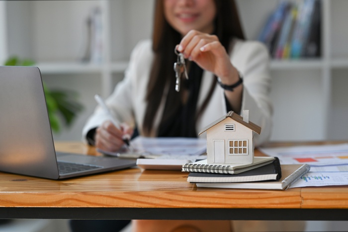 A mortgage lender holds out a house key