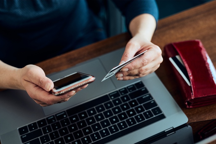 A woman shops online with her debit card