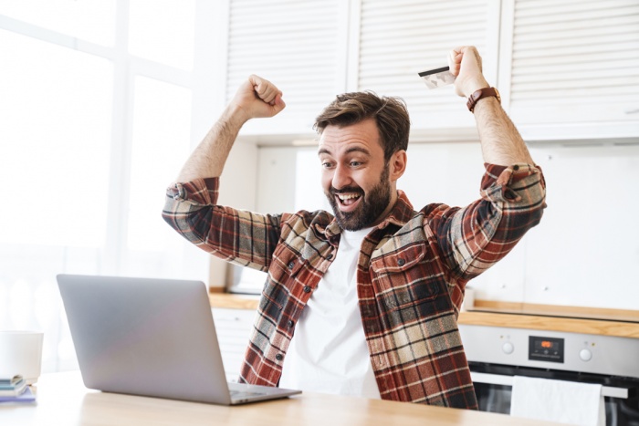 Excited man holding credit card