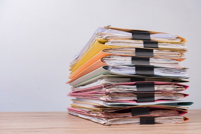 A stack of folders and documents sits on a table