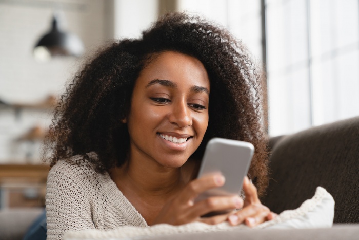 A woman browses social media on her smart phone.