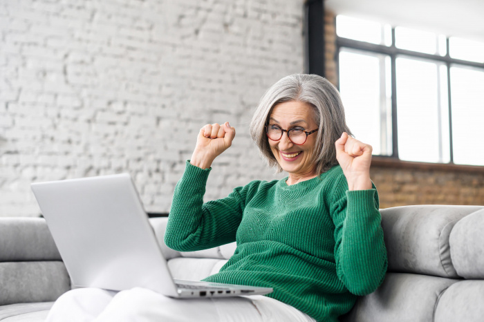 Woman smiling while looking at her laptop from home