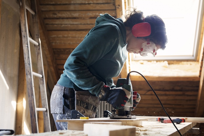 A woman works on renovating her home.