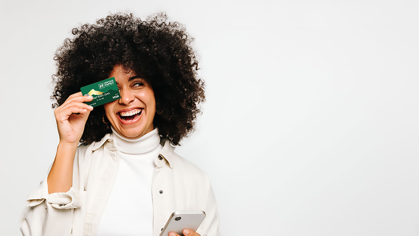 Cheerful young woman holding HFCU Visa