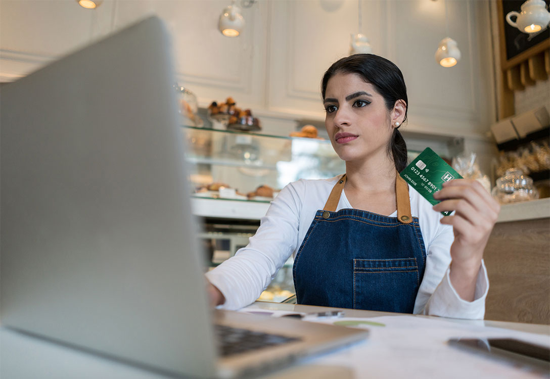 Female business owner holding HFCU business Visa