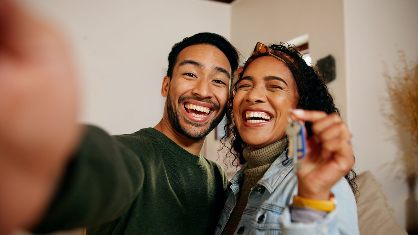 Happy couple smile with new house keys
