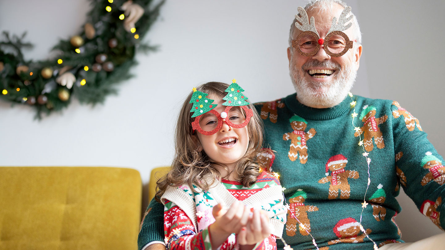 Older man with granddaughter dressed in holiday close