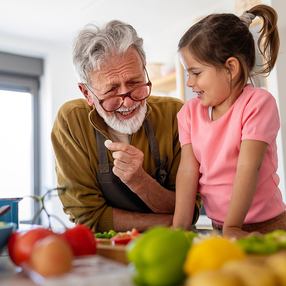 A girl cooks with her grandfather