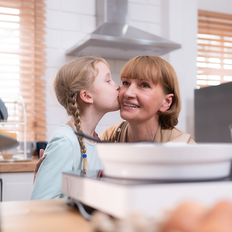 A grandmother gets a kiss on the cheek from her granddaughter