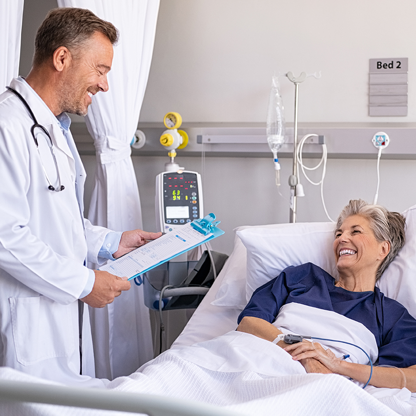 A doctor checks on an elderly woman patient in the hospital