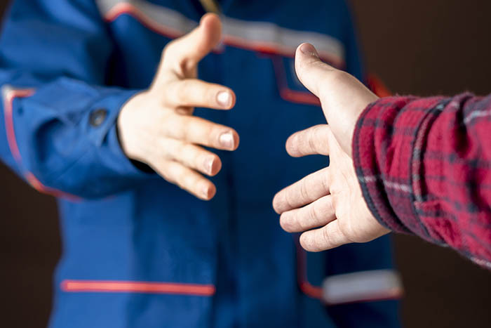 Two workers about to shake hands